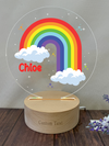 a wooden stand with a rainbow and clouds on it