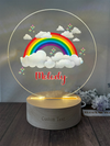 a glass plaque with a rainbow and clouds on it