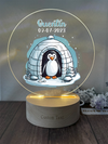 a personalized glass ornament with an image of a penguin in an i