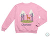 a pink sweatshirt with a deer and trees on it